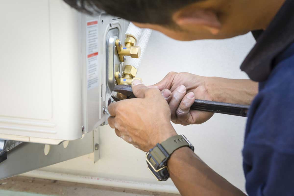 a person using a tool to fix a gas furnace