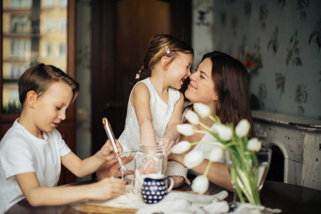 mother and children sitting at table smiling